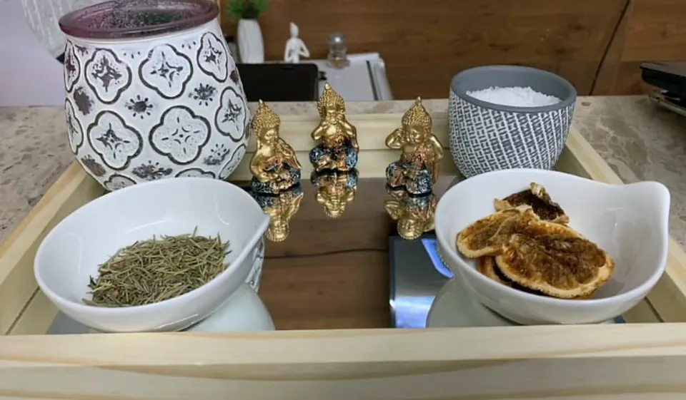 Bandeja com aromatizador, ervas secas, rodelas de laranja e pequenas imagens de Buda